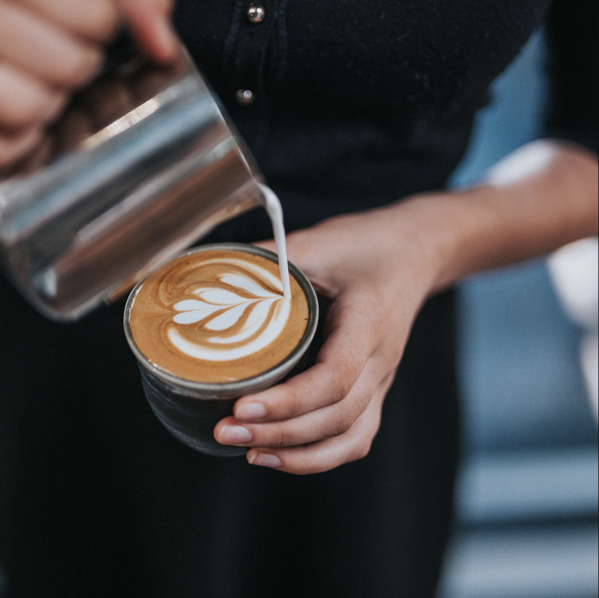 Barista pouring latte art at a Good Pick coffee event