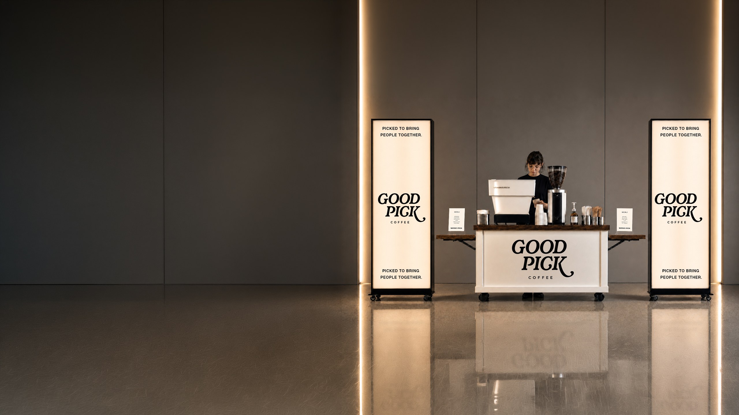 The Good Pick mobile coffee cart set up indoors with branded signage and a barista preparing drinks